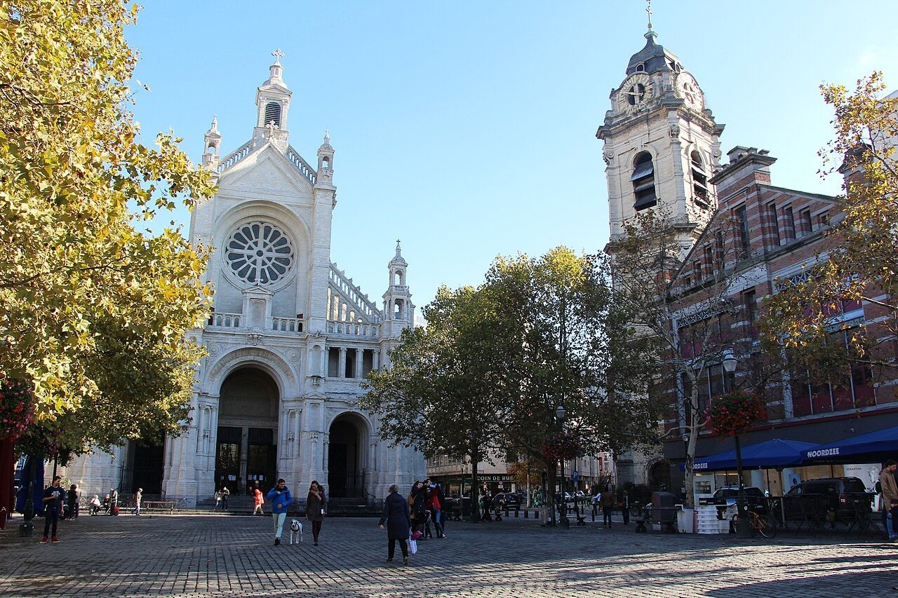 The stone facade of the church of Sainte-Catherine rising above the square in front of it.